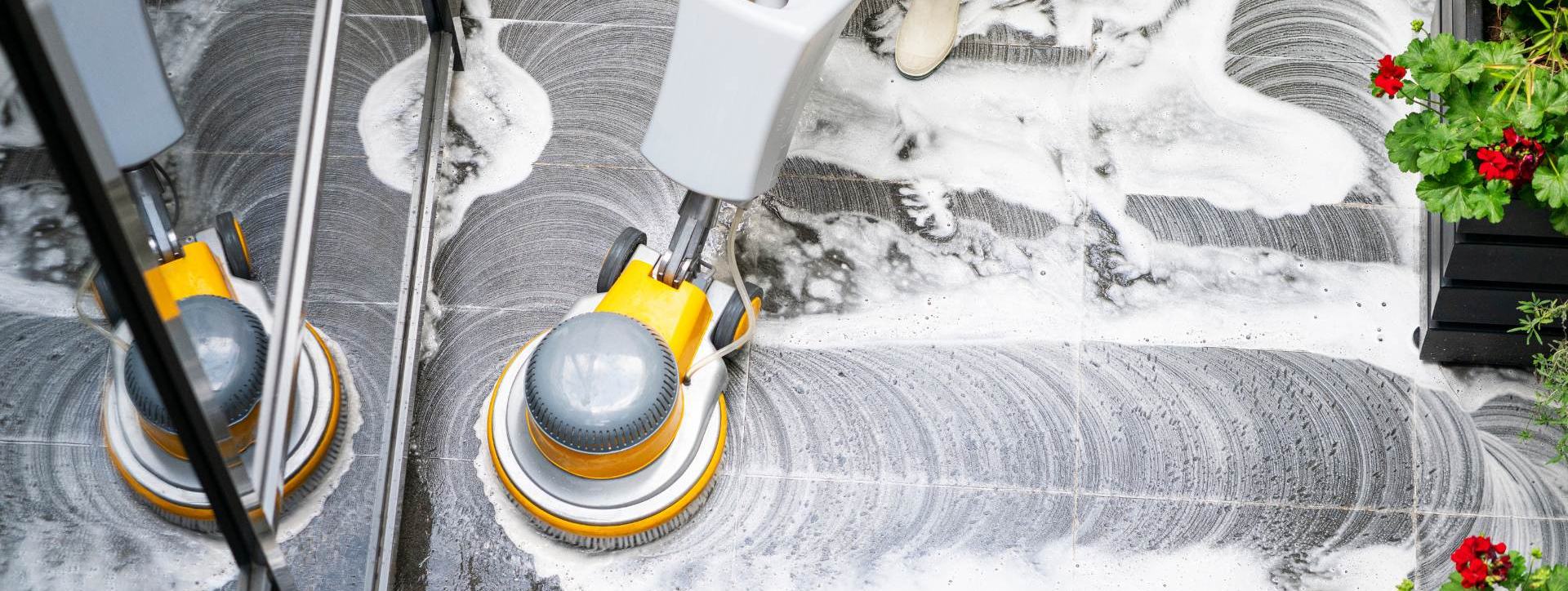 Máquina rotativa trabajando con agua y espuma sobre un piso de piedra