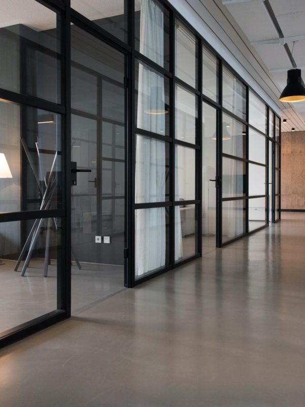 Limpieza-integral-de-oficinas Pasillo con divisiones de vidrio en un espacio de trabajo vacío